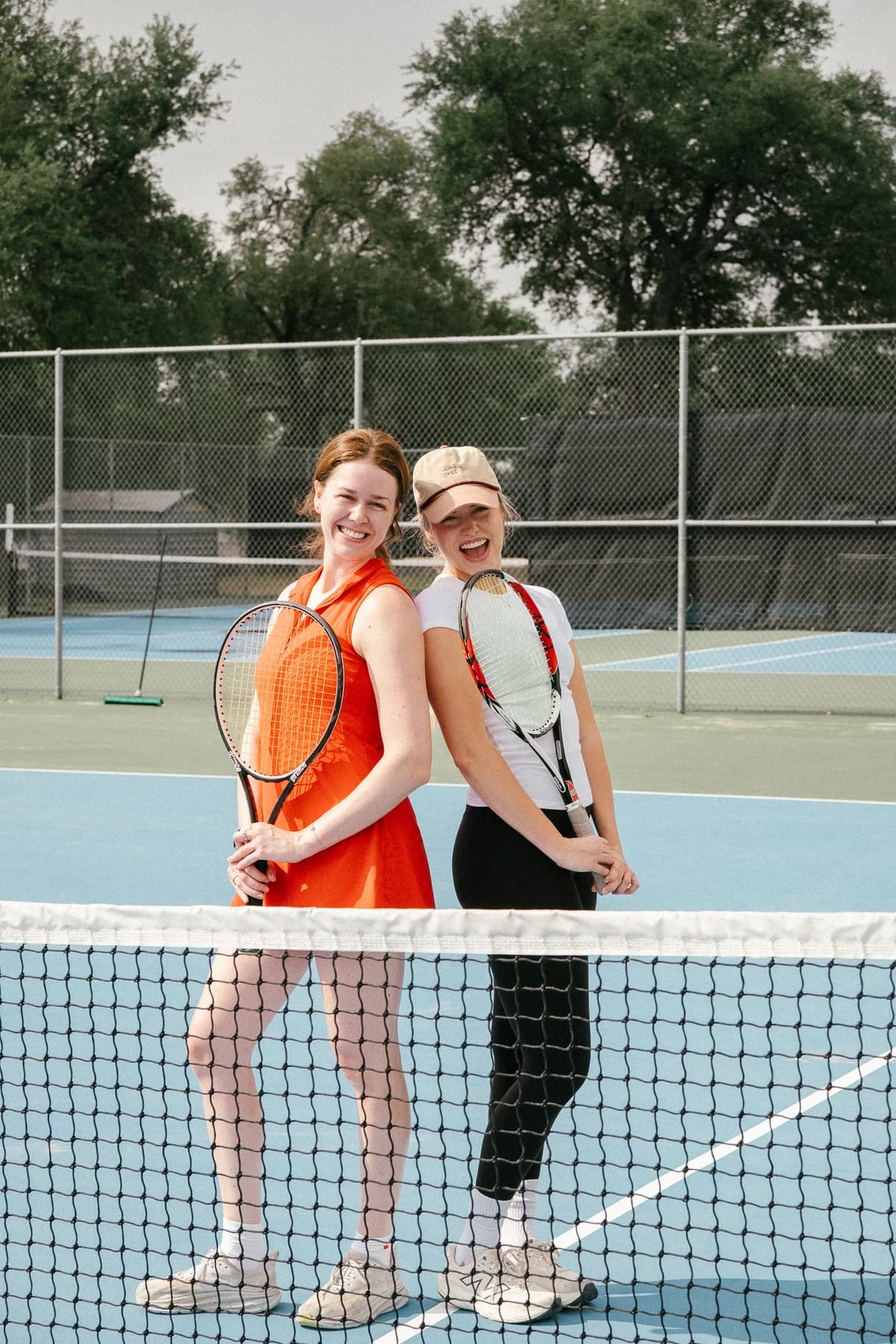 Two players with rackets at the net after a tennis match